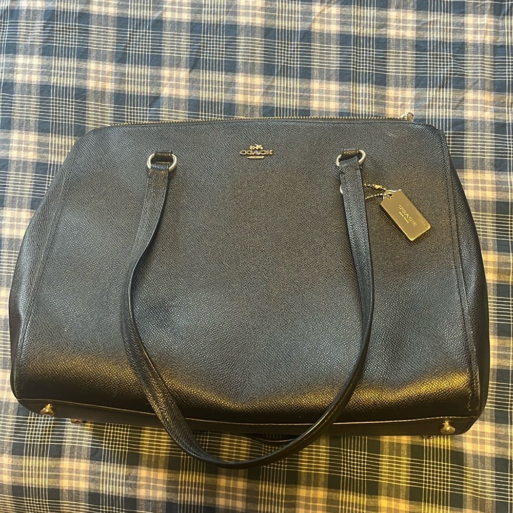 Black Coach purse with many compartments, zippers and gold casters on bottom